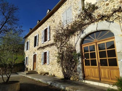 a stone building with a large wooden door at Gîte Les Hauts de Marère in Sévignacq-Meyracq