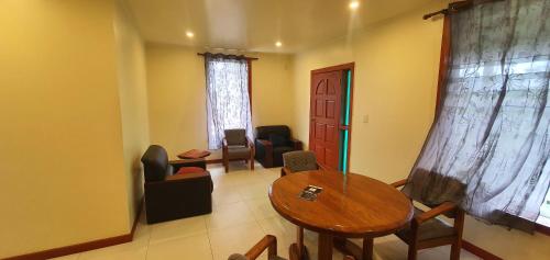 sala de estar con mesa y sillas en Lynn's Getaway Apartments, en Apia