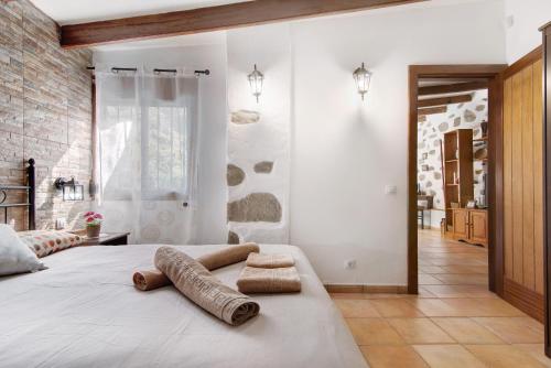 1 dormitorio con 1 cama con 2 toallas en Casa Abuela Fela, en Vega de San Mateo