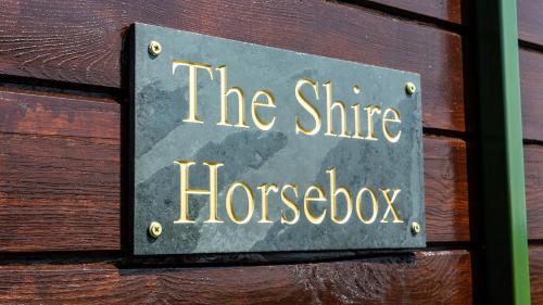 a sign that says the shire horsebox on a wooden wall at The Shire Luxury Converted Horse Lorry with private hot tub Cyfie Farm in Llanfyllin