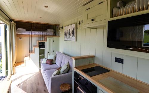uma sala de estar e cozinha numa casa minúscula em The Shire Luxury Converted Horse Lorry with private hot tub Cyfie Farm em Llanfyllin