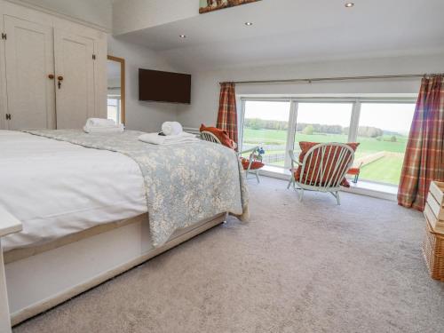 a bedroom with a bed and a large window at The Mustard Pot in Acklington