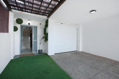 a white garage door with a green lawn at Vista Horizonte in Barranco Hondo
