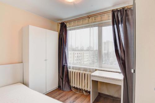 a bedroom with a bed and a window with a desk at Žirmūnų st 115 Vilnius Students Home LT in Vilnius