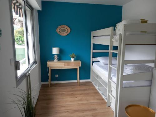 a bedroom with two bunk beds and a table at Appt calme au centre du Moulleau in Arcachon