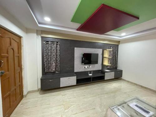 sala de estar con TV y puerta en Furnished 3 BHK in Prime Location Near Arilova - 3rd Floor en Visakhapatnam