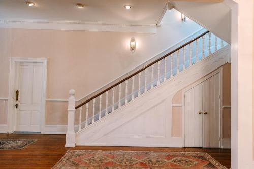 a staircase in a home with white walls and wood floors at Stanley House Inn in Marietta
