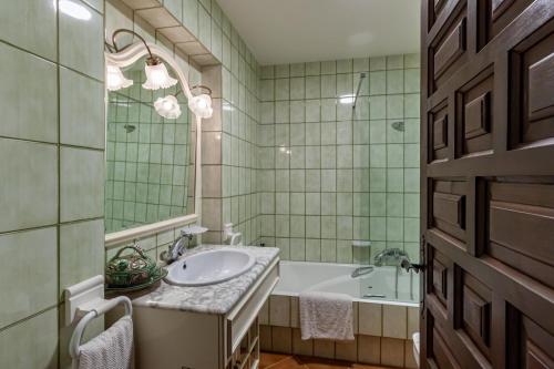 y baño con lavabo, bañera y espejo. en Masia Mimosa Pool house, en Darnius