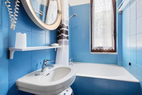 une salle de bain bleue avec un lavabo et un miroir dans l'établissement Appartamento Monolocale Moneglia 24, à Moneglia