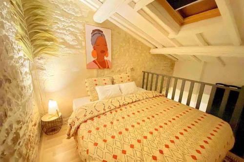 una camera da letto con un letto e un dipinto sul muro di Cocon à Deux Pas des Arènes - Charme & Confort a Nîmes