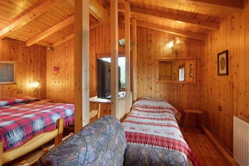 a bedroom with two beds in a wooden cabin at Dolce Casa vicino a Bormio in SantʼAntonio