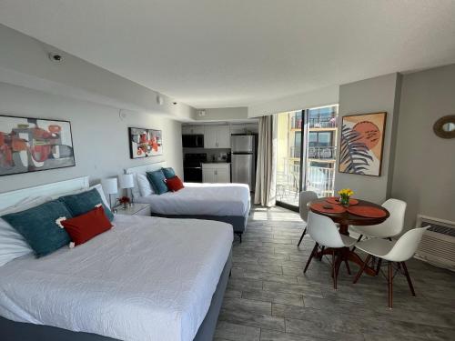 een hotelkamer met 2 bedden en een tafel en stoelen bij 1726 Ocean View Galore Pets are welcome in Myrtle Beach