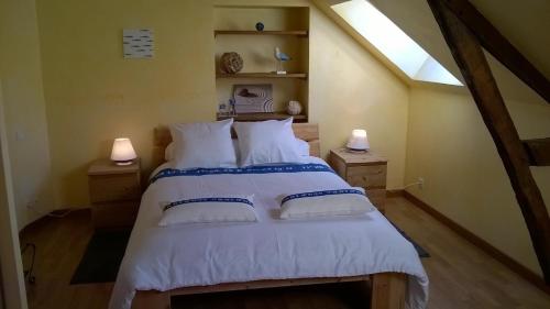 a bedroom with a large white bed with two lamps at La P'tit' Fugue in La Bouexière