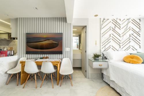 a bedroom with a dining table and chairs next to a bed at DELUX PRAIA Flats in Natal