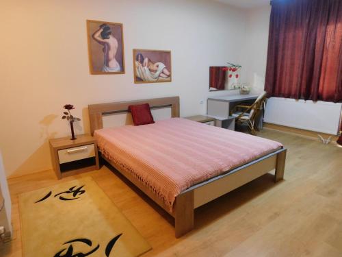 a bedroom with a bed and a desk and a table at Omeros in Gevgelija