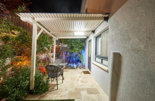 a patio with a table and chairs under a pergola at מור ולבונה - וילה מהממת ומפנקת למשפחות בגליל in Sifsufa