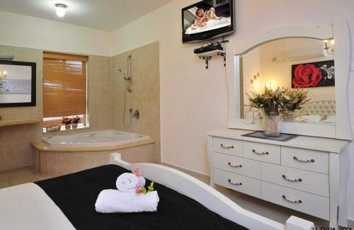 a bathroom with a bed and a tub and a sink at מור ולבונה - וילה מהממת ומפנקת למשפחות בגליל in Sifsufa