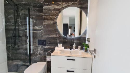 La salle de bains est pourvue d'un lavabo, de toilettes et d'un miroir. dans l'établissement Villa JAGGER Finestrat, à Finestrat