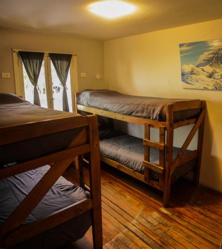 a room with two bunk beds and a window at HOPA-Home Patagonia Hostel in San Carlos de Bariloche