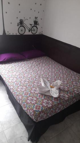 a bed with a white flower on top of it at El Amanecer La 27 in Manizales