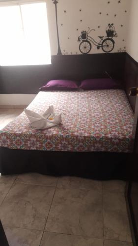 a bed with a pair of shoes sitting on it at El Amanecer La 27 in Manizales