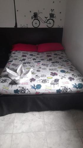 a bed with a comforter on top of it at El Amanecer La 27 in Manizales