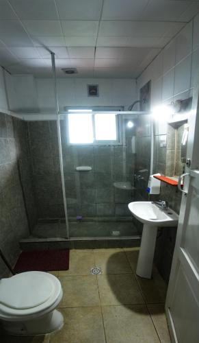 a bathroom with a shower and a toilet and a sink at HOPA-Home Patagonia Hostel in San Carlos de Bariloche