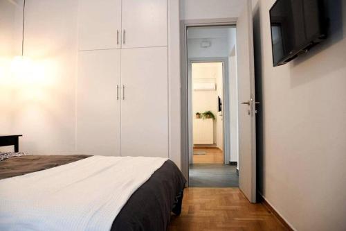 1 dormitorio con 1 cama y TV de pantalla plana en Διαμέρισμα vasiliki στο κέντρο της Αθήνας en Athens
