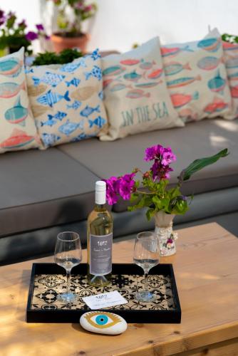 a tray with a bottle of wine and two glasses on a table at 1812 Caves 'n Mansion in Karterados
