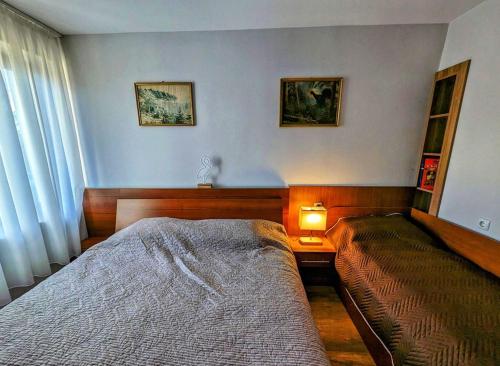 Un dormitorio con una cama y una mesa con una lámpara. en Студио за гости - Лили, en Ognyanovo