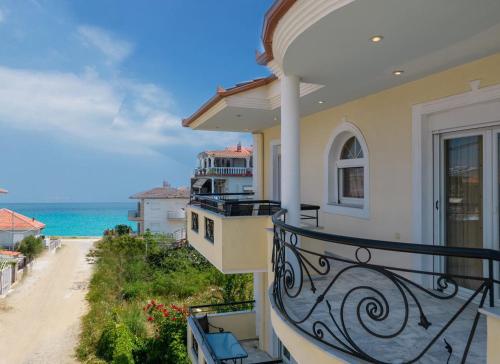 a balcony of a house with a view of the ocean at Prime Luxury Villa beach front in Nea Vrasna