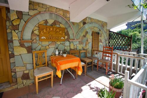 a patio with a table and chairs and a stone wall at Grandma's Home in Gjirokastër