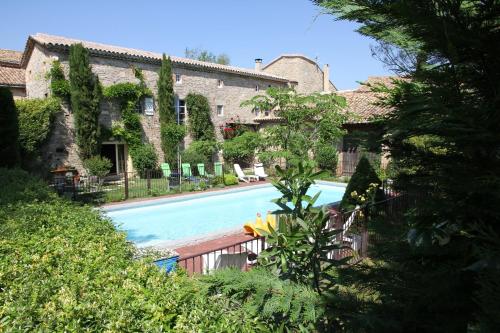 une piscine devant un immeuble dans l'établissement Vacances chez l'antiquaire 15 personnes 10 chambres, à Saint-Césaire-de-Gauzignan