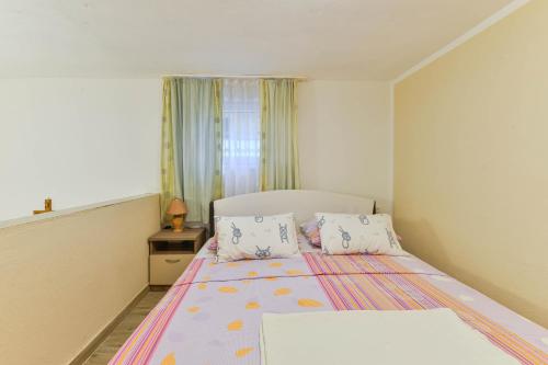 een kleine slaapkamer met een bed en een raam bij Borik Apartment Pedic in Zadar