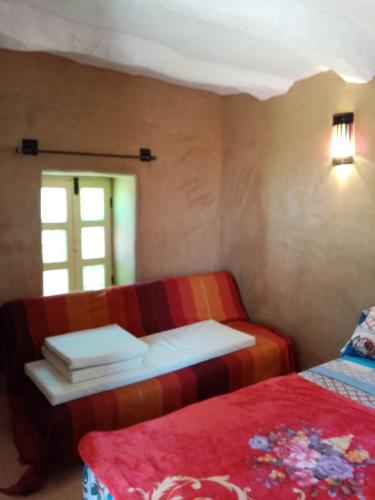 a small room with two beds and a window at Douar amazza in Taroudant