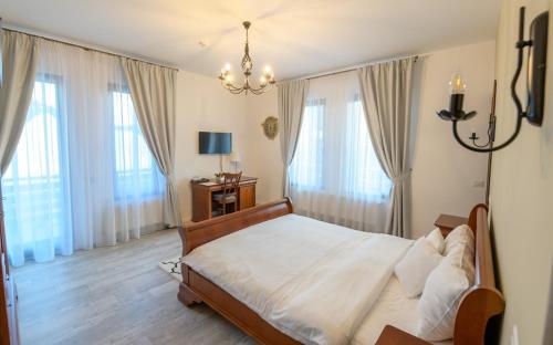 a bedroom with a large bed and a chandelier at Pensiunea Edelweiss, Putna in Putna