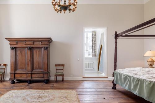 a bedroom with a bed and a wooden dresser at Jagdschloss Kotelow in Kotelow