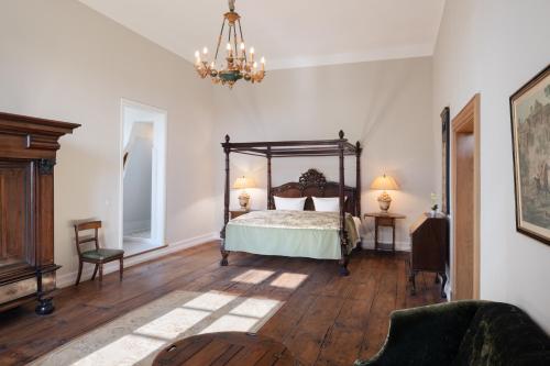 - une chambre avec un lit et un lustre dans l'établissement Jagdschloss Kotelow, à Kotelow