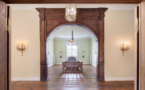 an archway leads into a room with a table and a window at Jagdschloss Kotelow in Kotelow