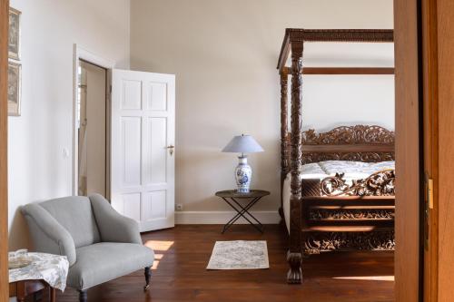 a bedroom with a bed and a chair and a mirror at Jagdschloss Kotelow in Kotelow