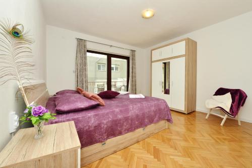 una camera con letto viola e tavolo di Apartmani Ivan a Kaštela (Castelli)