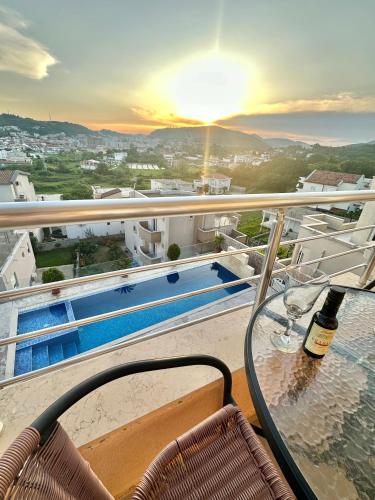 a balcony with a table and a bottle of wine at Queen Kodre Apartments in Ulcinj