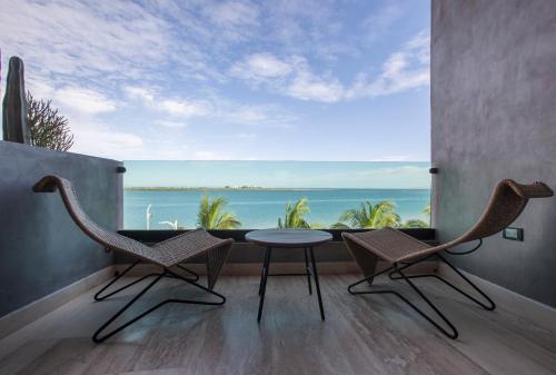 a room with a table and chairs and a view of the ocean at Malecón 1680 in La Paz