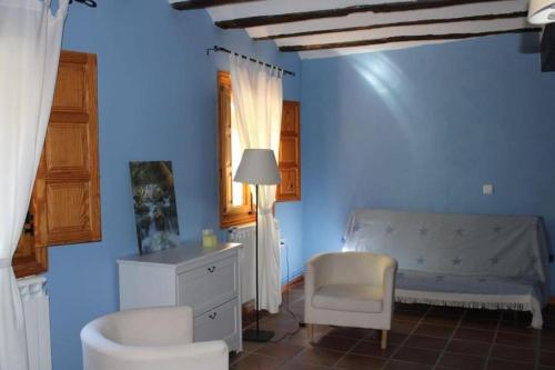 a blue bedroom with a bed and a chair at EL MOLINO De Villel in Villel