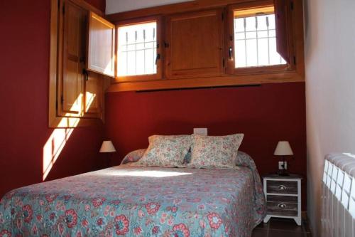 um quarto com uma cama com duas almofadas e duas janelas em EL MOLINO De Villel em Villel