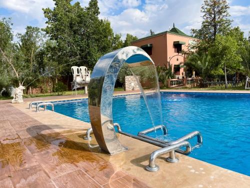 a swimming pool with a water slide in front of a swimming pool at Maison avec piscine et grand jardin 1 hectare in Marrakech