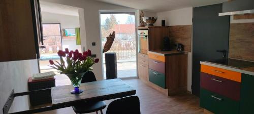 kuchnia ze stołem, na którym stoi wazon z kwiatami w obiekcie Moderne Vintage Ferienwohnung w mieście Bad Schussenried