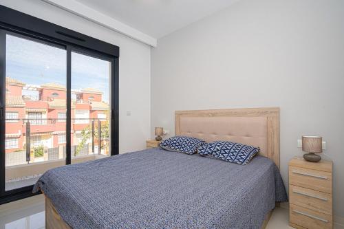 - une chambre avec un lit et une grande fenêtre dans l'établissement Vela, à Pilar de la Horadada