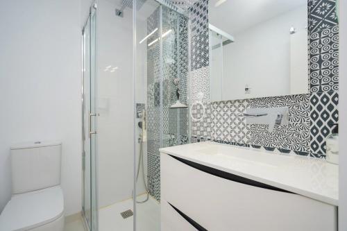 La salle de bains blanche est pourvue d'une douche et d'un lavabo. dans l'établissement Vela, à Pilar de la Horadada