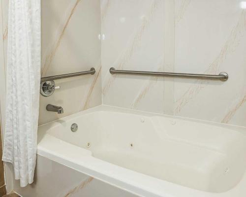 a white bath tub in a bathroom with a shower curtain at Comfort Inn Edinburgh - Columbus in Edinburgh